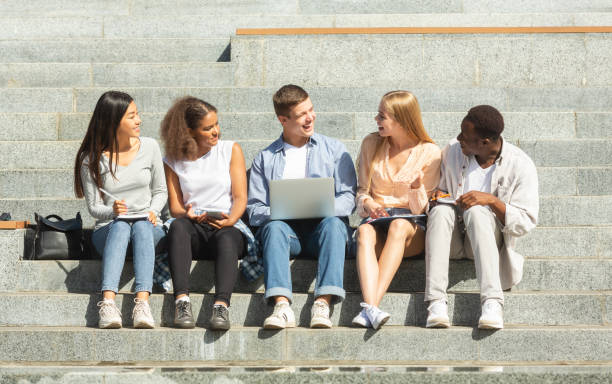 istock Cheerful students preparing group project, studying outdoors 1202924217