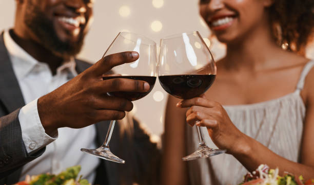 close up of african couple toasting with red wine - dating restaurant dinner couple imagens e fotografias de stock