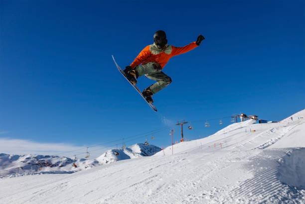 istock Snowboarder does a jumping trick in the snow Park 1202925450