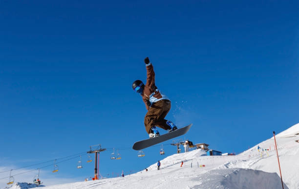 istock Male snowboarder against the blue sky 1202925455