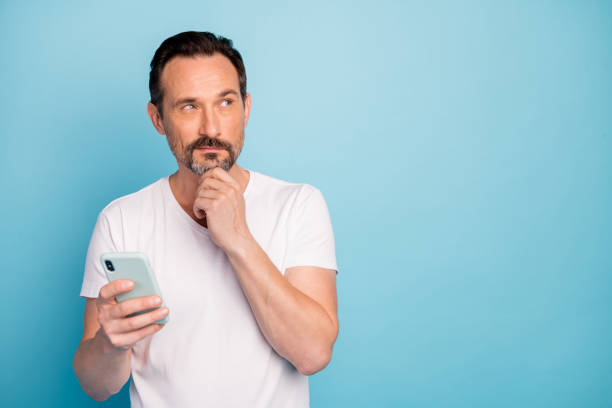 istock Close-up portrait of his he nice attractive bewildered guy using digital device creating new post writing comment isolated on bright vivid shine vibrant teal green blue turquoise color background 1202927826