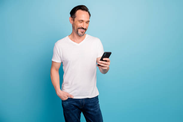 istock Portrait of his he nice attractive cheerful cheery guy spending free time using digital device smm comment isolated on bright vivid shine vibrant teal green blue turquoise color background 1202928246