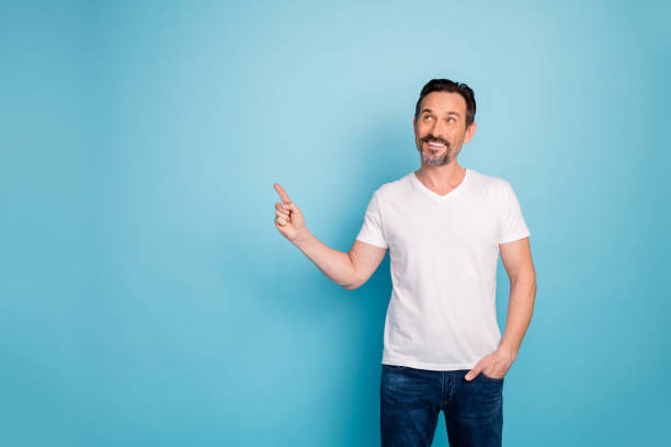 istock Portrait of his he nice attractive cheerful cheery curious guy showing copy empty blank space advert ad new novelty isolated on bright vivid shine vibrant teal green blue turquoise color background 1202929424