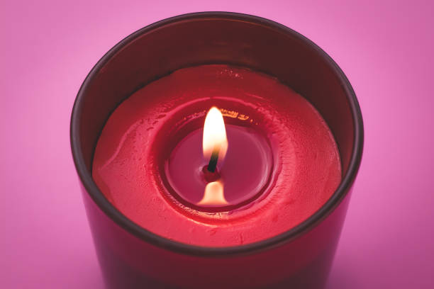 istock Candle flame close-up. Aromatherapy concept. Romantic atmosphere. Burning red candle on a pink background. 1202930656