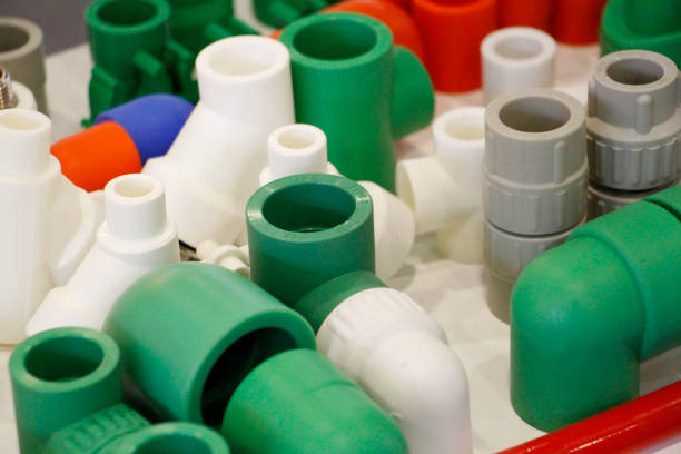 Plastic products used for industry. Many colored plugs, screws, valves, fittings, pipes, plastic adapters. Manufacture of plastic products. The concept of plastic products.