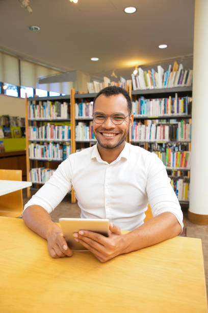 istock Front view of smiling cheerful man with tablet looking at camera 1202937946