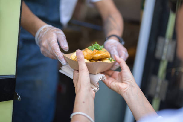 istock Street Food: Fried Fish and Chips Served in a Small Paperboard 1202940292