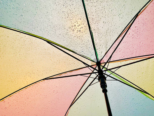 istock Colorful wet umbrella in the sunlight, abstract raindrops 1202942245