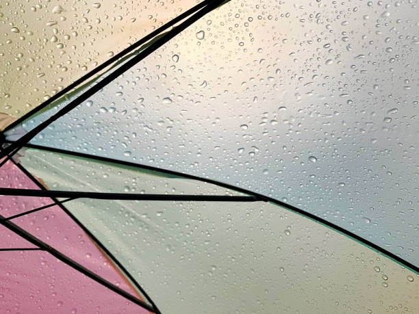 istock Colorful wet umbrella in the sunlight, abstract raindrops 1202942899