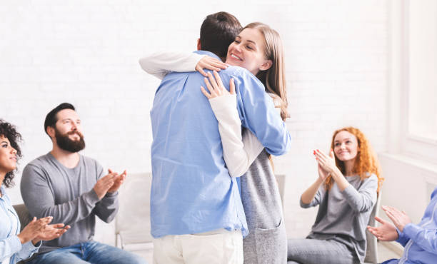 istock Happy spouses cuddling each other after group meeting with relationship therapist. 1202952068