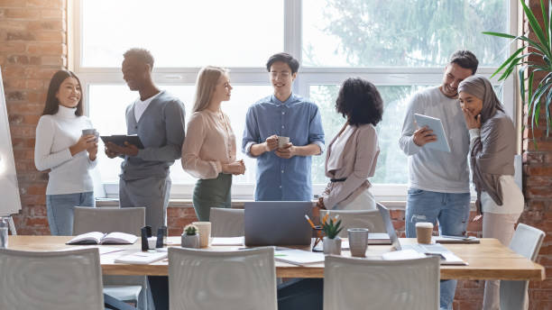 istock Group of multiracial young people talking while coffe break 1202952186