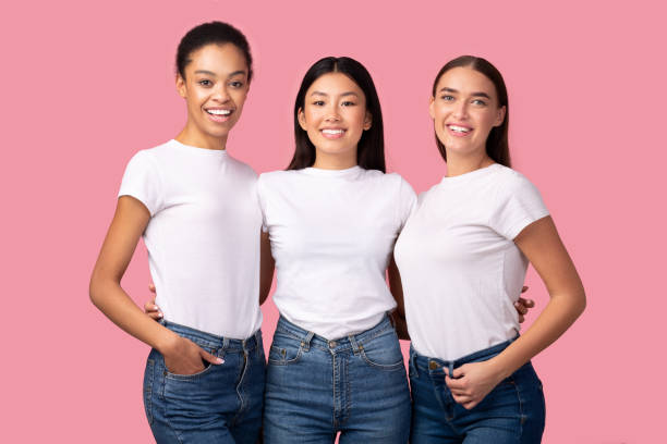 Three Pretty Girls Embracing Smiling To Camera Posing In Studio Three Pretty Girls Embracing Smiling To Camera Posing In Studio Over Pink Background. Female Friendship Concept japanese girlfriends stock pictures, royalty-free photos & images