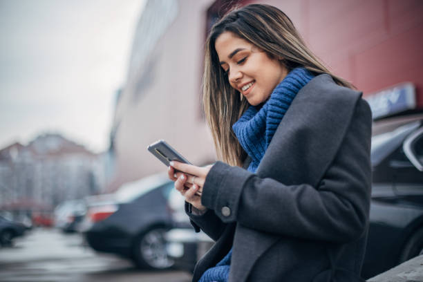 istock One young woman on the parking using smart phone 1202953600
