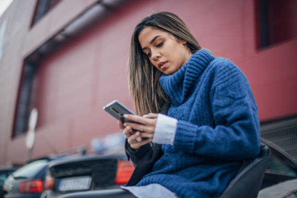 istock Woman on the parking using smart phone 1202953626
