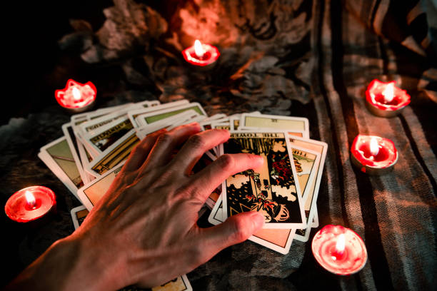 istock Hand on tarot card with candlelight on the darkness background for Astrology Occult Magic illustration - Magic Spiritual Horoscopes and Palm reading fortune teller concept 1202954531