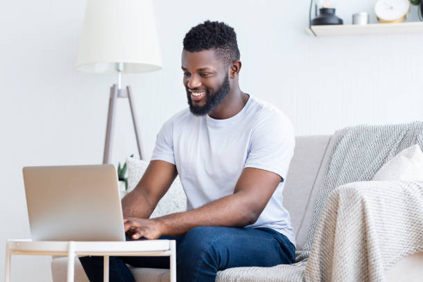 istock African guy playing video game on laptop at home 1202954677