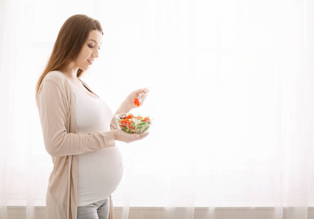 istock Pregnant lady enjoying fresh natural vegetable salad 1202954971
