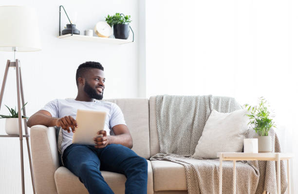 istock Positive african american with digital tablet looking aside 1202955121