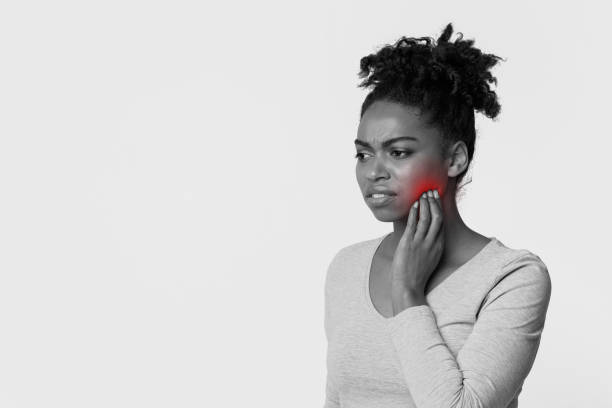 istock Young black woman touching cheek, feeling pain 1202955264