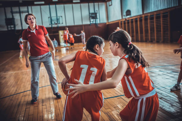 istock Female  School Basketball Team Playing Game 1202956888