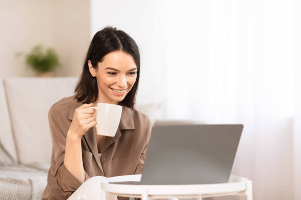 istock Young woman using laptop sitting on the floor 1202957471
