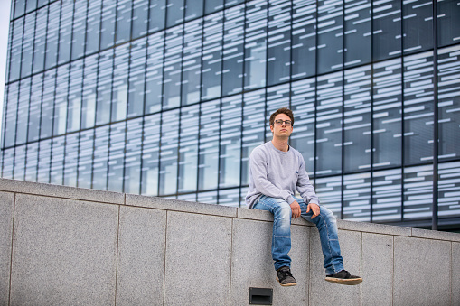 Portrait of a Young Adult Man Relaxing on Building Terrace.