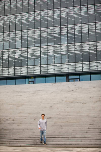 istock Young Adult Man Leaving a Large Building 1202957742