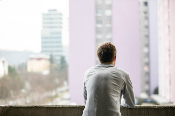 istock Contemplating Young Man Looking at City Streets 1202957997