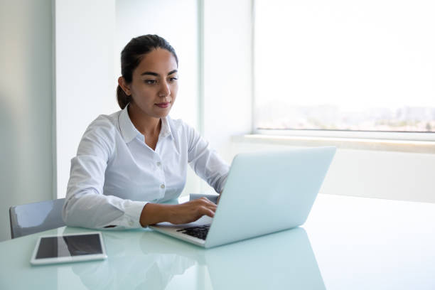 istock Serious young businesswoman using laptop in office 1202959634