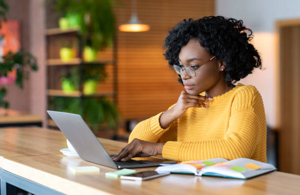 istock Black girl working in cafe, browsing on laptop 1202959871