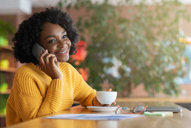 istock Happy young black woman drinking coffe at cafe, having conversation 1202960531