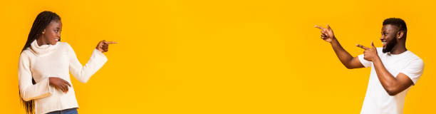 istock Black man and woman pointing at empty space over yellow 1202960810