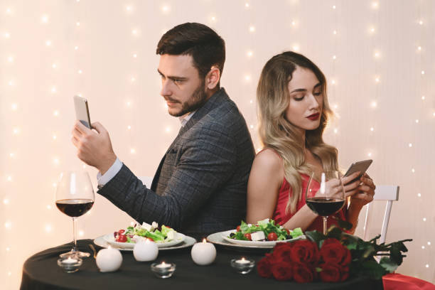 istock Bored Couple Using Smartphones Sitting Back To Back On Romantic Date 1202960929