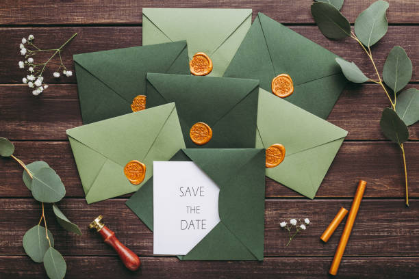 istock Green stylish envelopes with wedding postcards on wood 1202961097