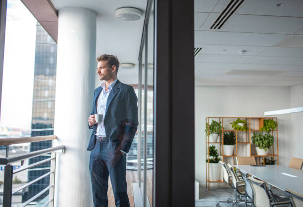 istock Businessman with Coffee Looking at View 1202961110