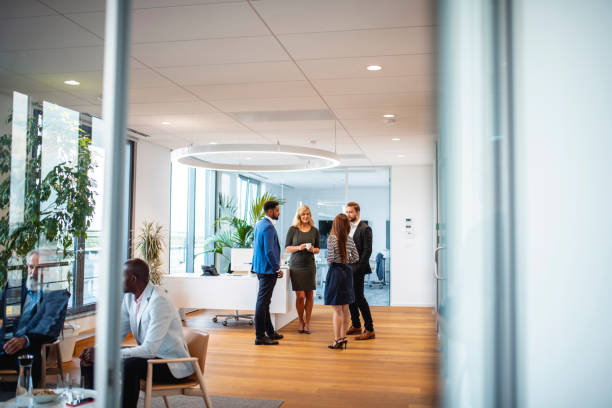 istock Relaxed Businesspeople Talking in Modern Lobby 1202961157