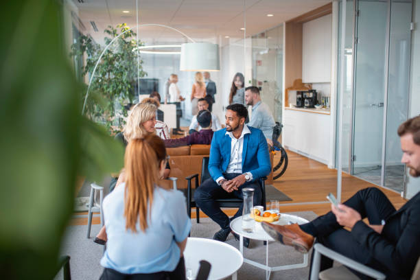 istock Business Groups Exchanging Ideas in Office Lobby 1202961219