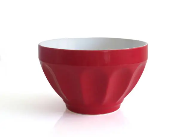 Elegant empty red ceramic bowl isolated on white background. Close up of red porcelain cup.