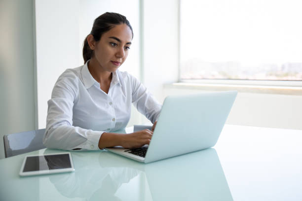istock Focused young businesswoman using laptop in office 1202962334