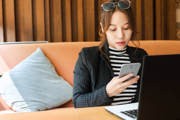 istock Asian working woman with mobile and laptop 1202962338