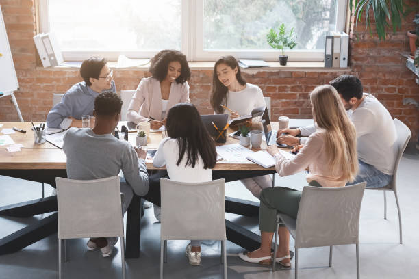 istock Creative international coworkers discussing new project office 1202962950