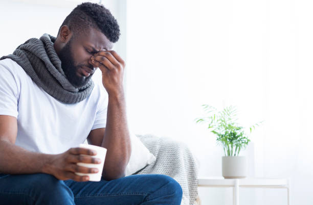 istock Sick african man drinking hot tea, suffering from headache 1202963097