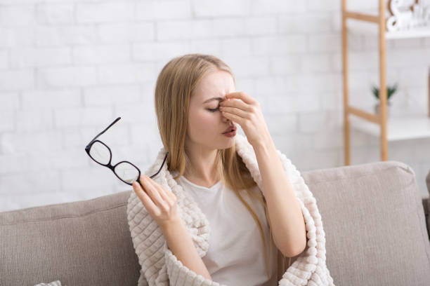 istock Tired young blonde man massaging nose bridge 1202963271