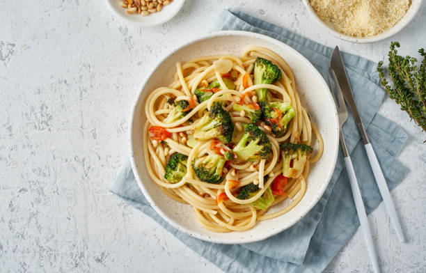 spaghetti con broccoli, bucatini con peperoni, aglio, pinoli. cibo per vegani, vegetariani - light vegetarian food garlic spice foto e immagini stock
