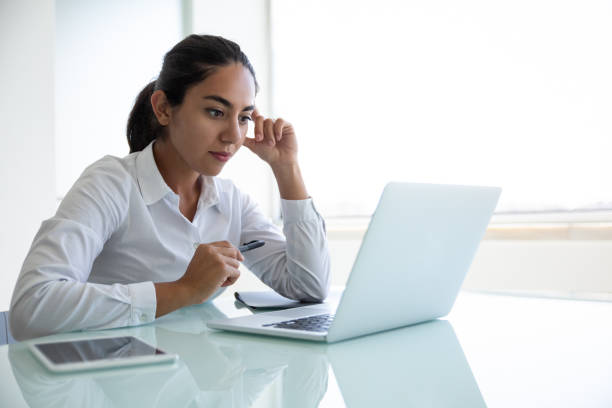 istock Concentrated young businesswoman using laptop in office 1202964472