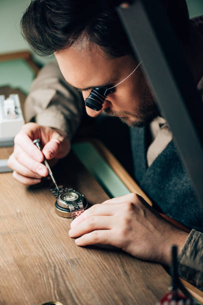 istock Selective focus of clockmaker working with wristwatch and screwdriver at table 1202965090