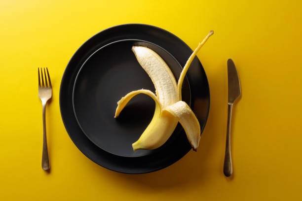 istock Ripe juicy banana on a black plate. 1202965125