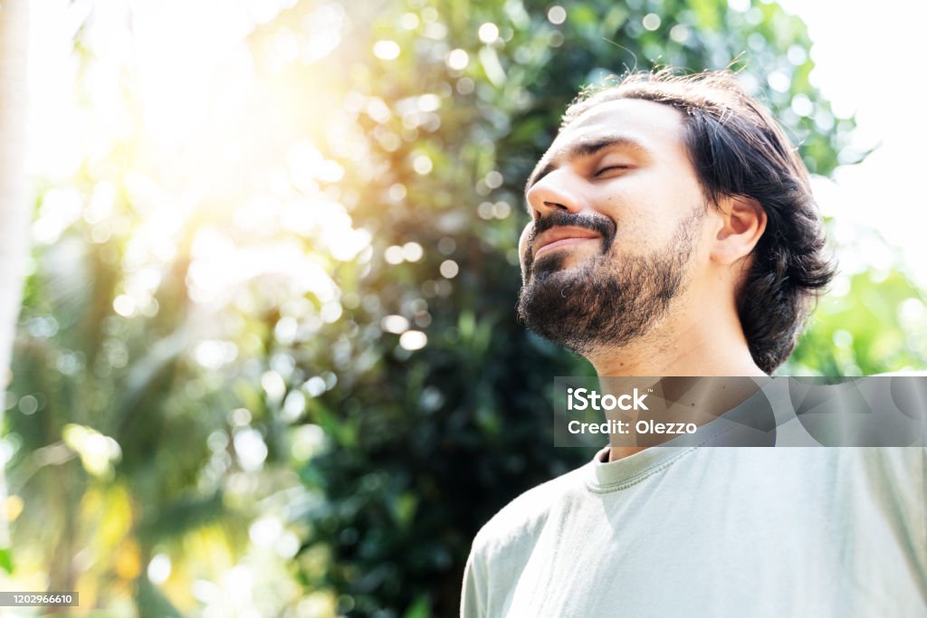 수염을 기운 한 남자가 화창한 여름날에 하늘을 올려 다닌 얼굴과 눈을 감고 공원에서 야외에서 명상을 하고 있습니다. 명상, 꿈, 웰빙 건강한 라이프 스타일의 개념 - 로열티 프리 남자 스톡 사진