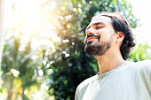 istock A bearded man is meditating outdoor in the park with face raised up to sky and eyes closed on sunny summer day. Concept of meditation, dreaming, wellbeing healthy lifestyle 1202966610