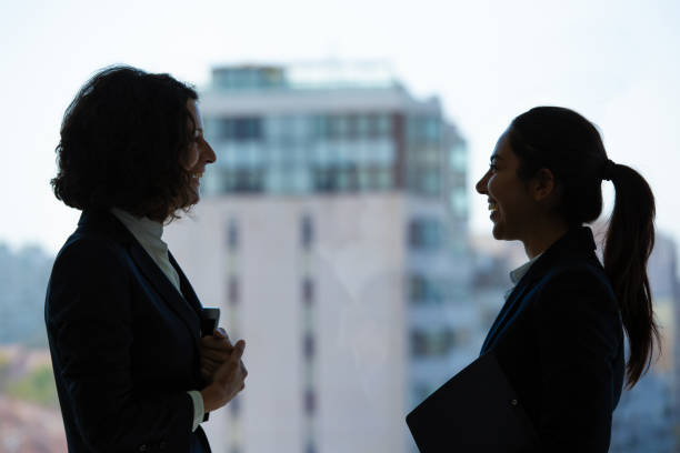 istock Happy businesswomen talking in office 1202967390